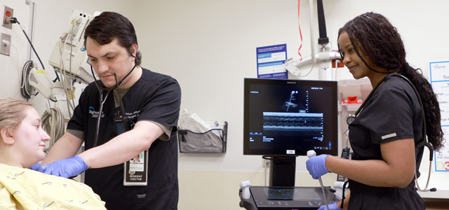 Two emergency medicine residents treating a patient.