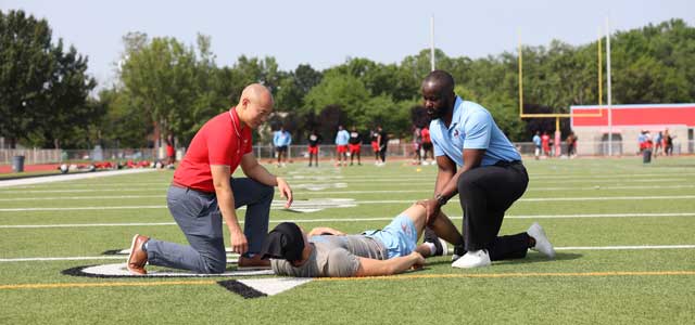 Sports medicine physicians treat an athlete on the football field.